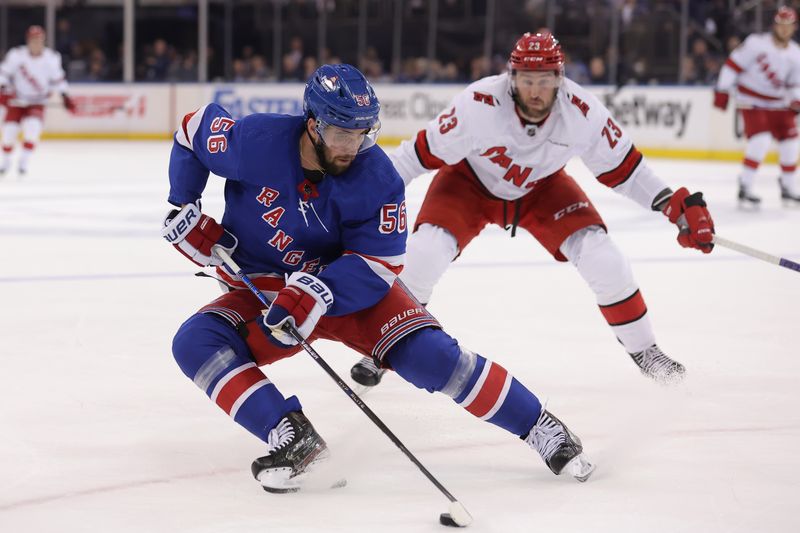 May 13, 2024; New York, New York, USA; New York Rangers defenseman Erik Gustafsson (56) skates with the puck against Carolina Hurricanes right wing Stefan Noesen (23) during the first period of game five of the second round of the 2024 Stanley Cup Playoffs at Madison Square Garden. Mandatory Credit: Brad Penner-USA TODAY Sports