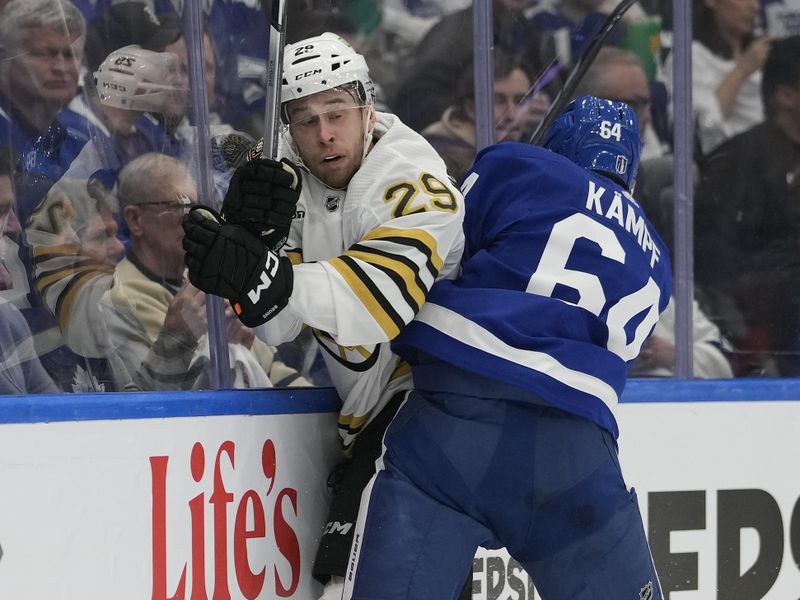 Apr 24, 2024; Toronto, Ontario, CAN; Toronto Maple Leafs forward David Kampf (64) checks Boston Bruins defenseman Parker Wotherspoon (29) into the boards during the first period of game three of the first round of the 2024 Stanley Cup Playoffs at Scotiabank Arena. Mandatory Credit: John E. Sokolowski-USA TODAY Sports