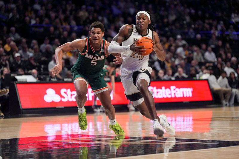 Jan 7, 2026; Winston-Salem, North Carolina, USA; Wake Forest Demon Deacons forward Tre'von Spillers (25) goes to the basket defended by Miami (FL) Hurricanes forward Malik Reneau (5) during the first half at Lawrence Joel Veterans Memorial Coliseum. Mandatory Credit: Jim Dedmon-Imagn Images