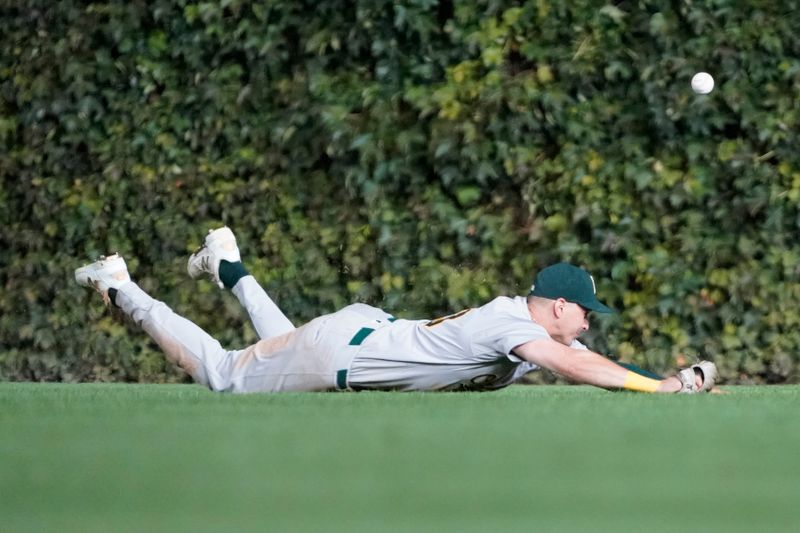 Sep 16, 2024; Chicago, Illinois, USA; Oakland Athletics outfielder JJ Bleday (33) misses a catch that resulted in a triple hit by Chicago Cubs catcher Miguel Amaya (not pictured) during the seventh inning at Wrigley Field. Mandatory Credit: David Banks-Imagn Images