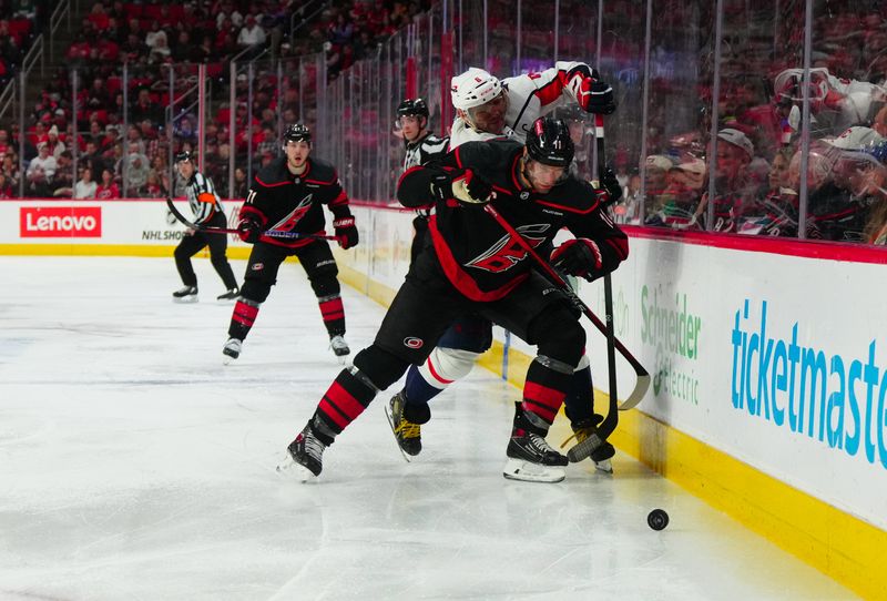 Apr 5, 2024; Raleigh, North Carolina, USA; Carolina Hurricanes center Jordan Staal (11) checks Washington Capitals left wing Alex Ovechkin (8) during the second period at PNC Arena. Mandatory Credit: James Guillory-USA TODAY Sports