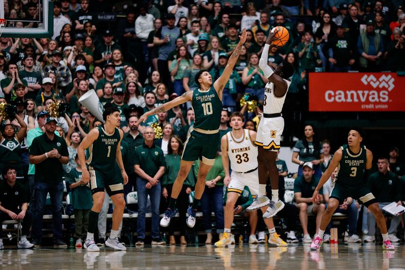 Mar 2, 2024; Fort Collins, Colorado, USA; Wyoming Cowboys guard Akuel Kot (13) attempts a shot under pressure from Colorado State Rams guard Nique Clifford (10) in the first half at Moby Arena. Mandatory Credit: Isaiah J. Downing-USA TODAY Sports