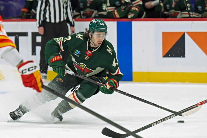 Jan 29, 2026; Saint Paul, Minnesota, USA;  Minnesota Wild defensemen Quinn Hughes (43) controls the puck against the Calgary Flames during the second period at Grand Casino Arena. Mandatory Credit: Nick Wosika-Imagn Images