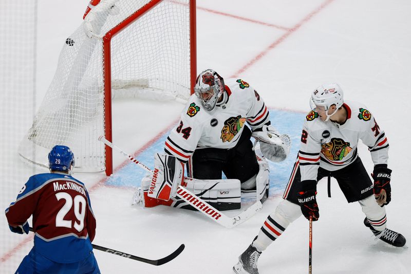 Oct 19, 2023; Denver, Colorado, USA; Colorado Avalanche center Nathan MacKinnon (29) scores a goal against Chicago Blackhawks goaltender Petr Mrazek (34) as left wing Lukas Reichel (27) defends in the third period at Ball Arena. Mandatory Credit: Isaiah J. Downing-USA TODAY Sports