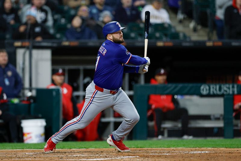 May 23, 2025; Chicago, Illinois, USA; Texas Rangers first baseman Jake Burger (21) hits an RBI-double against the Chicago White Sox during the sixth inning at Rate Field. Mandatory Credit: Kamil Krzaczynski-Imagn Images