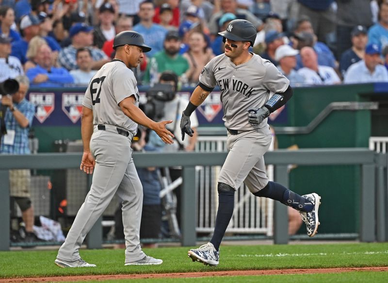 Jun 11, 2024; Kansas City, Missouri, USA; New York Yankees catcher Austin Wells (28) gets a hand from New York Yankees third base coach Luis Rojas (67) after hitting a three run home run in the fourth inning against the Kansas City Royals at Kauffman Stadium. Mandatory Credit: Peter Aiken-USA TODAY Sports