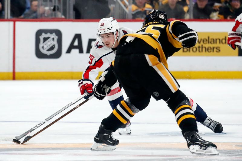 Jan 2, 2024; Pittsburgh, Pennsylvania, USA;  Washington Capitals center Hendrix Lapierre (29) moves the puck against Pittsburgh Penguins defenseman Erik Karlsson (65) during the second period at PPG Paints Arena. Mandatory Credit: Charles LeClaire-USA TODAY Sports