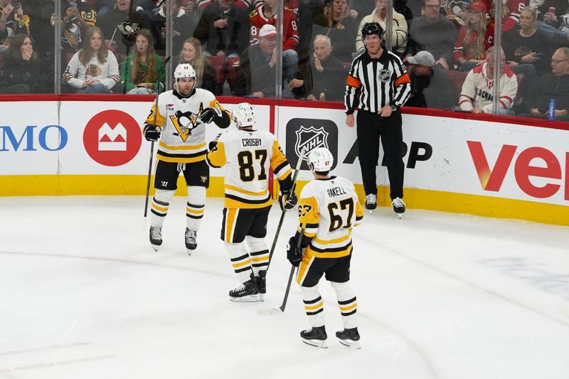 Dec 28, 2025; Chicago, Illinois, USA; Pittsburgh Penguins right wing Bryan Rust (17) celebrates scoring a goal with center Sidney Crosby (87) and right wing Rickard Rakell (67) against the Chicago Blackhawks during the first period at United Center. Mandatory Credit: David Banks-Imagn Images