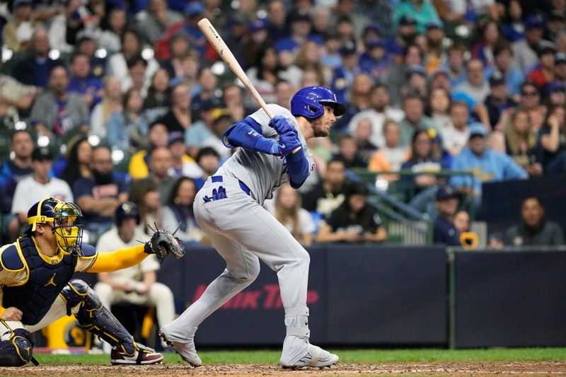 May 28, 2024; Milwaukee, Wisconsin, USA;  Chicago Cubs center fielder Cody Bellinger (24) singles during the tenth inning against the Milwaukee Brewers at American Family Field. Mandatory Credit: Jeff Hanisch-USA TODAY Sports