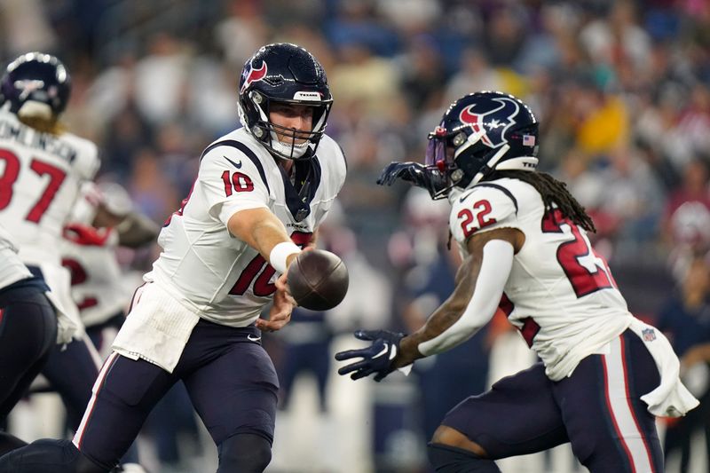 Houston Texans quarterback Davis Mills (10) hands off the ball to running back Mike Boone (22) during the first half of an NFL preseason football game against the New England Patriots, Thursday, Aug. 10, 2023, in Foxborough, Mass. (AP Photo/Steven Senne)