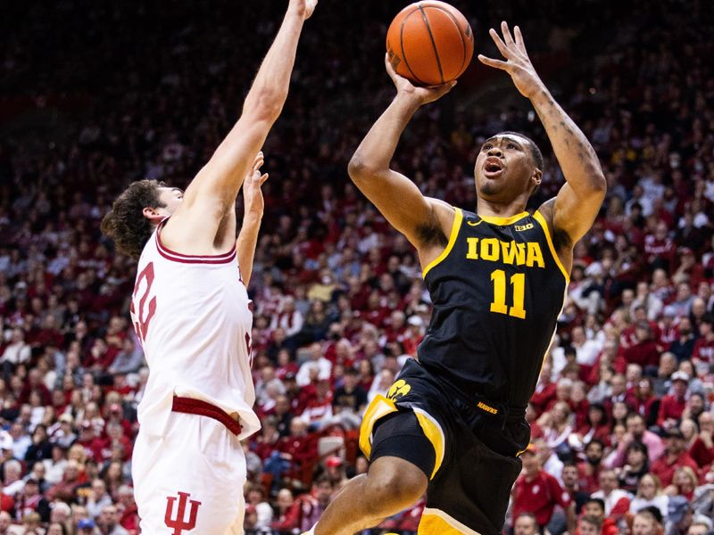 Jan 30, 2024; Bloomington, Indiana, USA; Iowa Hawkeyes guard Tony Perkins (11) shoots the ball while Indiana Hoosiers guard Trey Galloway (32) defends in the second half at Simon Skjodt Assembly Hall. Mandatory Credit: Trevor Ruszkowski-USA TODAY Sports