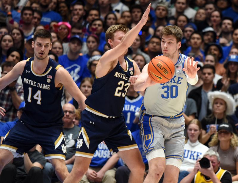 Feb 14, 2023; Durham, North Carolina, USA; Duke Blue Devils center Kyle Filipowski(30) throws a pass as Notre Dame Fighting Irish guard Dane Goodwin (23) defends during the first half at Cameron Indoor Stadium. Mandatory Credit: Rob Kinnan-USA TODAY Sports