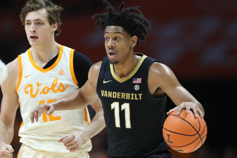 Feb 15, 2025; Knoxville, Tennessee, USA; Vanderbilt Commodores guard AJ Hoggard (11) moves the ball against Tennessee Volunteers forward Cade Phillips (12) during the first half at Thompson-Boling Arena at Food City Center. Mandatory Credit: Randy Sartin-Imagn Images