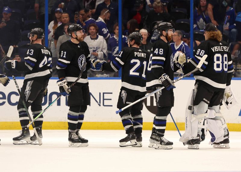 Apr 17, 2024; Tampa, Florida, USA; Tampa Bay Lightning defenseman Darren Raddysh (43), defenseman Erik Cernak (81), center Brayden Point (21), defenseman Nick Perbix (48) and goaltender Andrei Vasilevskiy (88) celebrate after they defeated the Toronto Maple Leafs at Amalie Arena. Mandatory Credit: Kim Klement Neitzel-USA TODAY Sports