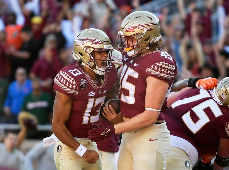 Nov 13, 2021; Tallahassee, Florida, USA; Florida State Seminoles quarterback Jordan Travis (13) celebrates after running the ball for a touchdown during the first quarter against the Miami Hurricanes at Doak S. Campbell Stadium. Mandatory Credit: Melina Myers-USA TODAY Sports