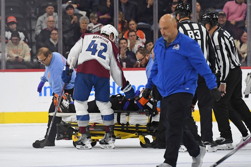 Nov 18, 2024; Philadelphia, Pennsylvania, USA; Referee Barry Anderson (20) is carted off the ice after colliding with a player during game between Philadelphia Flyers and Colorado Avalanche in the first period at Wells Fargo Center. Mandatory Credit: Eric Hartline-Imagn Images