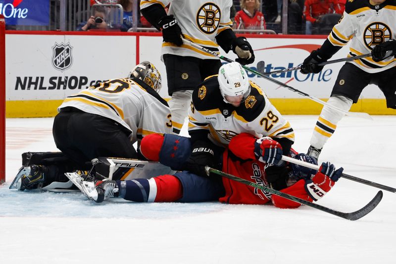 Oct 5, 2024; Washington, District of Columbia, USA; Boston Bruins defenseman Parker Wotherspoon (29) punches Washington Capitals left wing Andrew Mangiapane (88) after colliding into Bruins goaltender Brandon Bussi (30) at Capital One Arena. Mandatory Credit: Geoff Burke-Imagn Images