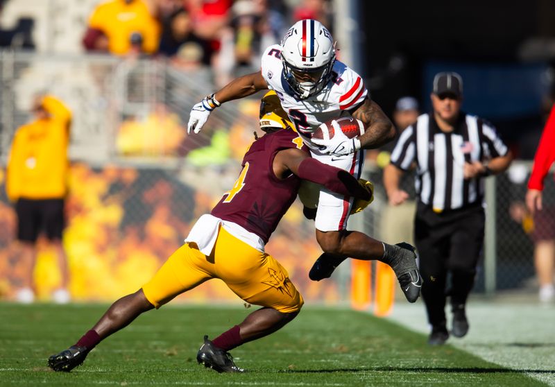 Nov 25, 2023; Tempe, Arizona, USA; Arizona Wildcats running back Jacob Cowing (2) is tackled by Arizona State Sun Devils defensive back Demetries Ford (4) in the first half of the Territorial Cup at Mountain America Stadium. Mandatory Credit: Mark J. Rebilas-USA TODAY Sports