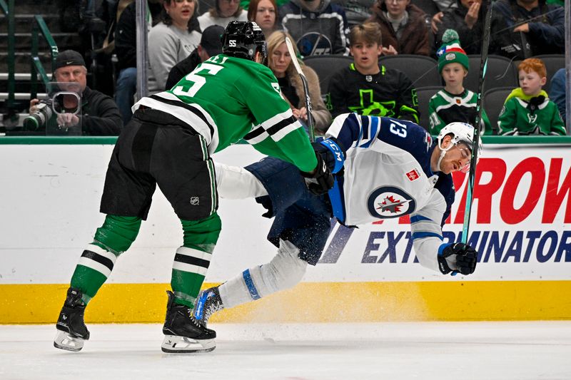 Dec 1, 2024; Dallas, Texas, USA; Dallas Stars defenseman Thomas Harley (55) checks Winnipeg Jets center Gabriel Vilardi (13) during the first period at the American Airlines Center. Mandatory Credit: Jerome Miron-Imagn Images