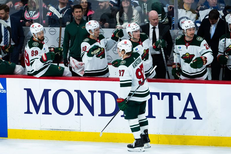 Feb 20, 2024; Winnipeg, Manitoba, CAN; Minnesota Wild forward Kirill Kaprizov (97) is congratulated by his team mates on his goal against Winnipeg Jets goalie Laurent Boissoit (39) during third period at Canada Life Centre. Mandatory Credit: Terrence Lee-USA TODAY Sports