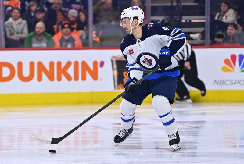 Jan 22, 2023; Philadelphia, Pennsylvania, USA; Winnipeg Jets defenseman Neal Pionk (4) controls the puck against the Philadelphia Flyers in the second period at Wells Fargo Center. Mandatory Credit: Kyle Ross-USA TODAY Sports