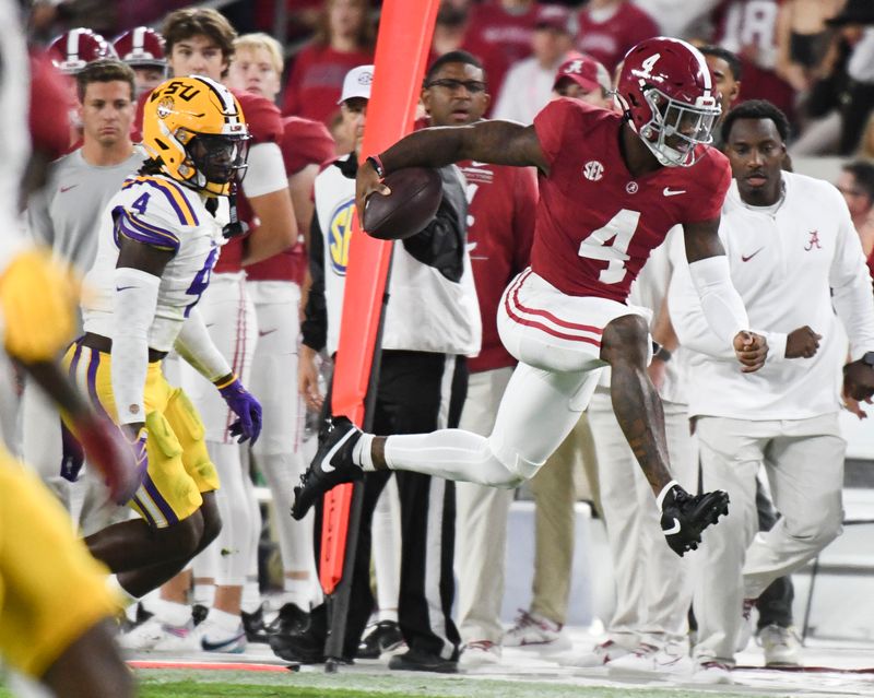 Nov 4, 2023; Tuscaloosa, Alabama, USA;  Alabama Crimson Tide quarterback Jalen Milroe (4) leaps along the sidelines as he runs for a first down against LSU at Bryant-Denny Stadium. Mandatory Credit: Gary Cosby Jr.-USA TODAY Sports