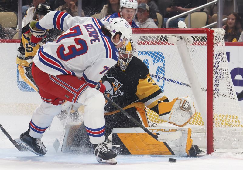 Oct 11, 2025; Pittsburgh, Pennsylvania, USA;  Pittsburgh Penguins goaltender Arturs Silovs (37) makes a save against New York Rangers center Matt Rempe (73) during the second period at PPG Paints Arena. Mandatory Credit: Charles LeClaire-Imagn Images