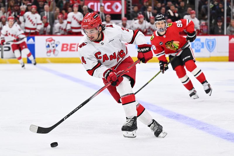 Apr 14, 2024; Chicago, Illinois, USA;  Carolina Hurricanes forward Seth Jarvis (24) controls the puck in the second period against the Chicago Blackhawks at United Center. Mandatory Credit: Jamie Sabau-USA TODAY Sports