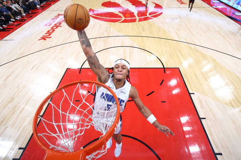 TORONTO, CANADA - MARCH 15:  Paolo Banchero #5 of the Orlando Magic drives to the basket during the game against the Toronto Raptors on March 15, 2024 at the Scotiabank Arena in Toronto, Ontario, Canada.  NOTE TO USER: User expressly acknowledges and agrees that, by downloading and or using this Photograph, user is consenting to the terms and conditions of the Getty Images License Agreement.  Mandatory Copyright Notice: Copyright 2024 NBAE (Photo by Vaughn Ridley/NBAE via Getty Images)