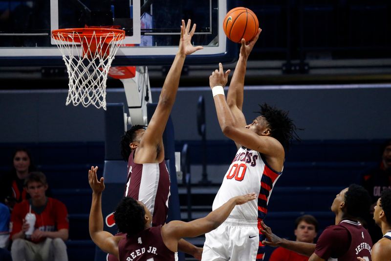 Feb 18, 2023; Oxford, Mississippi, USA; Mississippi Rebels forward Jayveous McKinnis (0) shoots as Mississippi State Bulldogs forward Will McNair Jr. (13) defends during the first half at The Sandy and John Black Pavilion at Ole Miss. Mandatory Credit: Petre Thomas-USA TODAY Sports