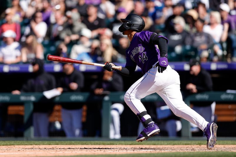 Apr 21, 2024; Denver, Colorado, USA; Colorado Rockies shortstop Ezequiel Tovar (14) hits an RBI single in the tenth inning against the Seattle Mariners at Coors Field. Mandatory Credit: Isaiah J. Downing-USA TODAY Sports