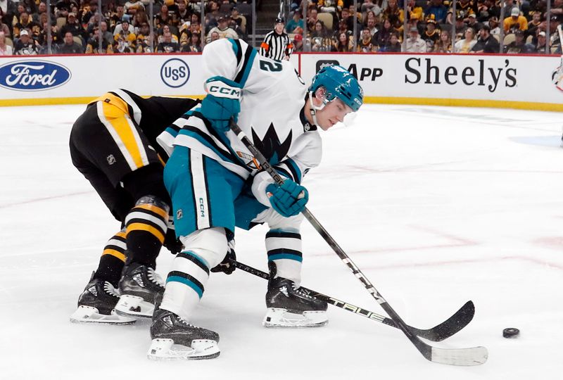 Mar 14, 2024; Pittsburgh, Pennsylvania, USA; San Jose Sharks left wing William Eklund (72) moves the puck against Pittsburgh Penguins defenseman John Ludvig (rear) during the second period at PPG Paints Arena. Pittsburgh won 6-3. Mandatory Credit: Charles LeClaire-USA TODAY Sports