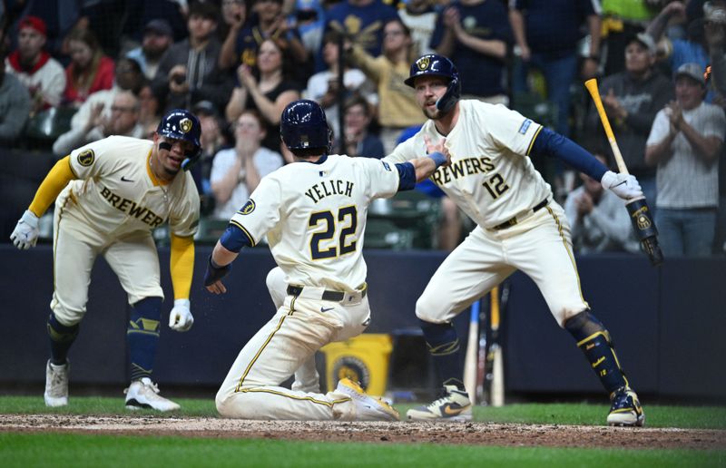 May 10, 2024; Milwaukee, Wisconsin, USA; Milwaukee Brewers outfielder Christian Yelich (22) ia congratulated by Milwaukee Brewers first base Rhys Hoskins (12) after scoring a run against the St. Louis Cardinals in the fifth inning at American Family Field. Mandatory Credit: Michael McLoone-USA TODAY Sports