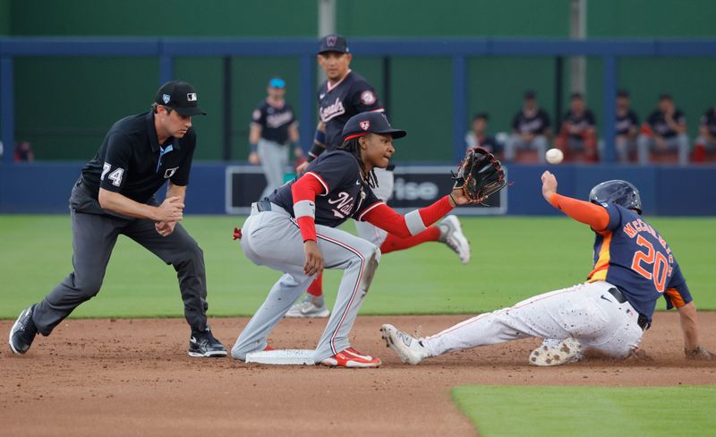 Mar 18, 2024; West Palm Beach, Florida, USA;  Houston Astros center fielder Chas McCormick (20) slides safely into second as Washington Nationals short stop C.J. Abrams  waits on the ball with umpire John Tumpane (74) looking on during the first inning at The Ballpark of the Palm Beaches. Mandatory Credit: Reinhold Matay-USA TODAY Sports