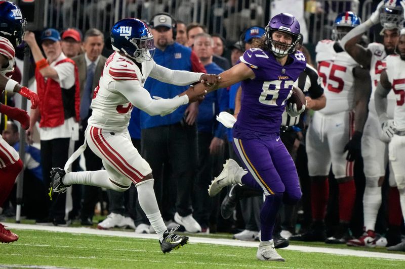 Minnesota Vikings tight end T.J. Hockenson (87) tries to break a tackle by New York Giants safety Tony Jefferson (36) after catching a pass during the first half of an NFL wild card playoff football game, Sunday, Jan. 15, 2023, in Minneapolis. (AP Photo/Charlie Neibergall)