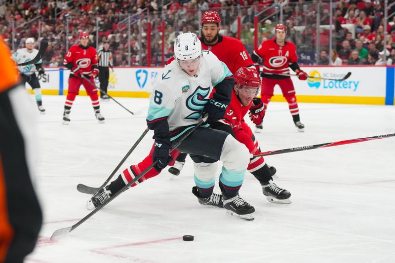 Jan 10, 2026; Raleigh, North Carolina, USA;  Seattle Kraken defenseman Cale Fleury (8) skates with the puck against Carolina Hurricanes right wing Andrei Svechnikov (37) during the second period at Lenovo Center. Mandatory Credit: James Guillory-Imagn Images