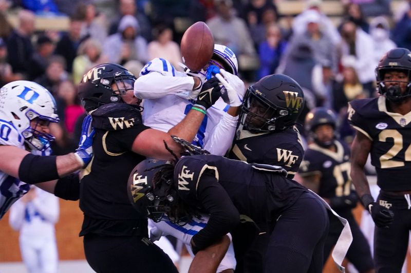 Oct 30, 2021; Winston-Salem, North Carolina, USA;  Duke Blue Devils wide receiver Darrell Harding Jr. (3) fumbles the ball after being hit by Wake Forest Demon Deacons quarterback Sam Hartman (10) defensive back Ja'Sir Taylor (6) and defensive back Malik Mustapha (27) during the second half during the second half at Truist Field. Mandatory Credit: James Guillory-USA TODAY Sports