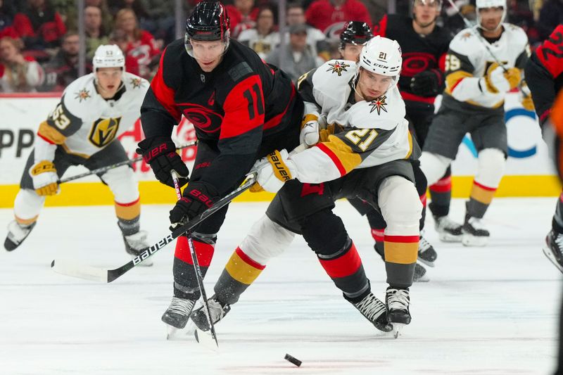 Mar 11, 2023; Raleigh, North Carolina, USA;  Carolina Hurricanes center Jordan Staal (11) and Vegas Golden Knights center Brett Howden (21) battle over the puck during the first period at PNC Arena. Mandatory Credit: James Guillory-USA TODAY Sports