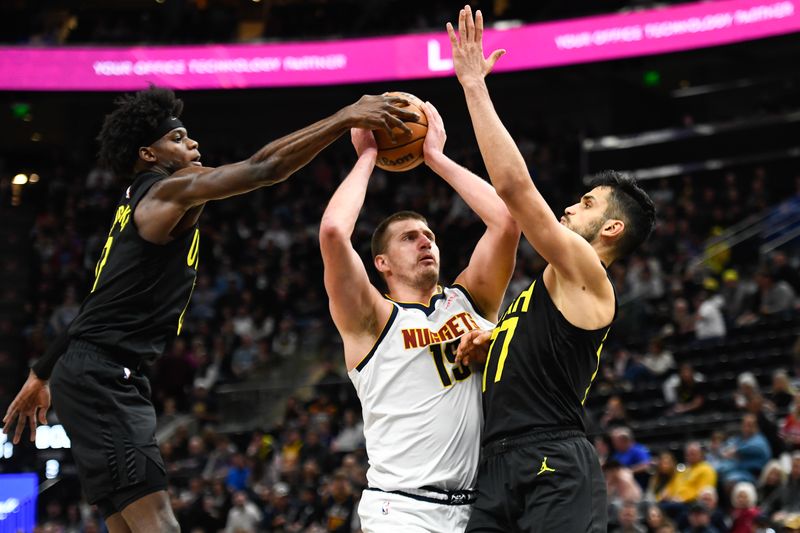 SALT LAKE CITY, UTAH - APRIL 09: Nikola Jokic #15 of the Denver Nuggets goes up for a shot against Taylor Hendricks #0 and Omer Yurtseven #77 of the Utah Jazz during the second half at Delta Center on April 09, 2024 in Salt Lake City, Utah. NOTE TO USER: User expressly acknowledges and agrees that, by downloading and or using this photograph, User is consenting to the terms and conditions of the Getty Images License Agreement.  (Photo by Alex Goodlett/Getty Images)