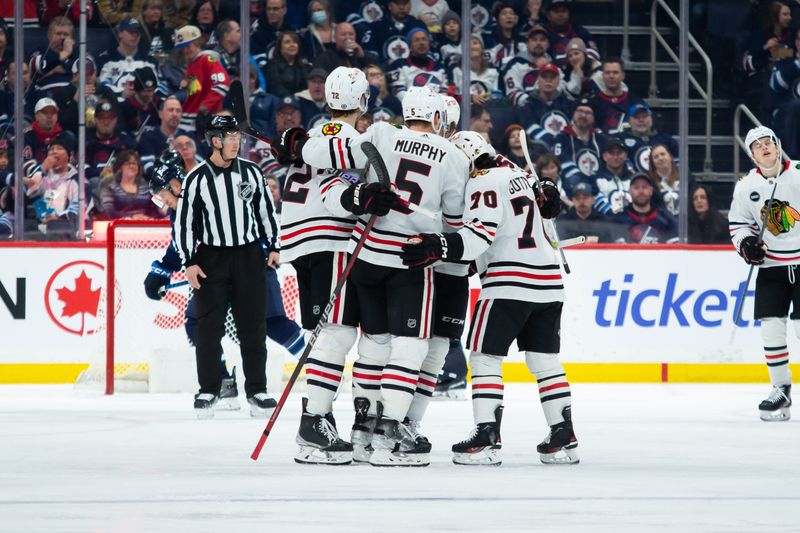 Jan 11, 2024; Winnipeg, Manitoba, CAN; Chicago Blackhawks defenseman Connor Murphy (5) is congratulated by his team mates on his goal against the Winnipeg Jets during the second period at Canada Life Centre. Mandatory Credit: Terrence Lee-USA TODAY Sports