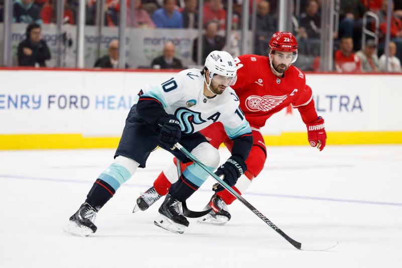 Nov 18, 2025; Detroit, Michigan, USA; Seattle Kraken center Matty Beniers (10) and Detroit Red Wings center Dylan Larkin (71) chase after the puck in the second period at Little Caesars Arena. Mandatory Credit: Rick Osentoski-Imagn Images