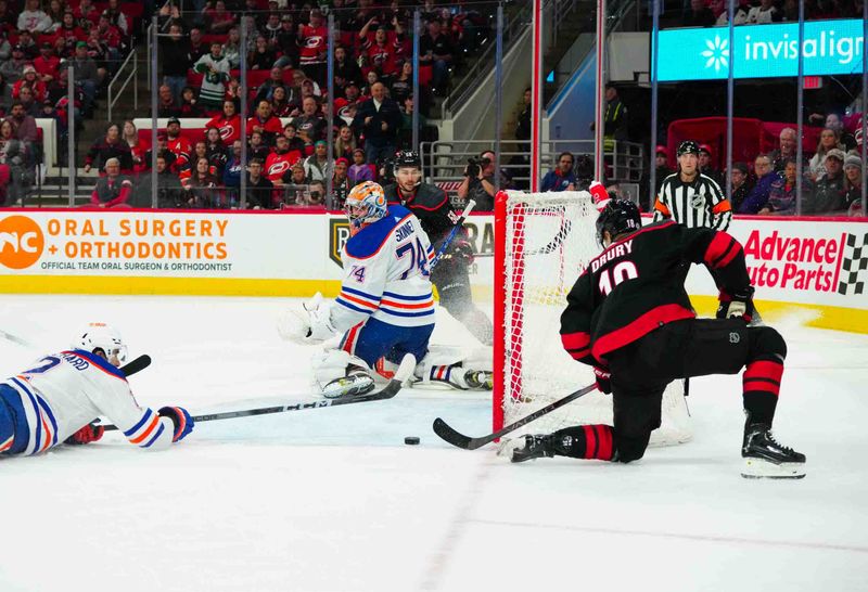 Nov 22, 2023; Raleigh, North Carolina, USA; Carolina Hurricanes center Jack Drury (18) scores a goal past Edmonton Oilers goaltender Stuart Skinner (74) during the first period at PNC Arena. Mandatory Credit: James Guillory-USA TODAY Sports