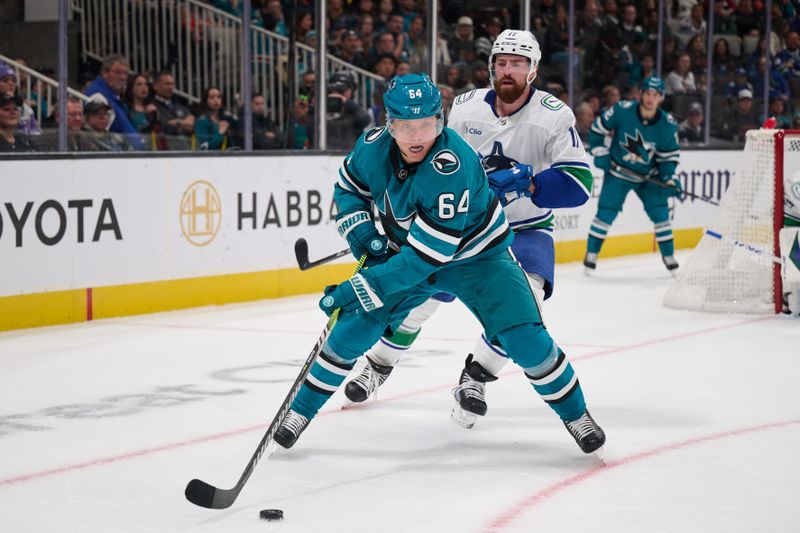 Nov 2, 2024; San Jose, California, USA; San Jose Sharks center Mikael Granlund (64) plays the puck against Vancouver Canucks defenseman Filip Hronek (17) during the second period at SAP Center at San Jose. Mandatory Credit: Robert Edwards-Imagn Images