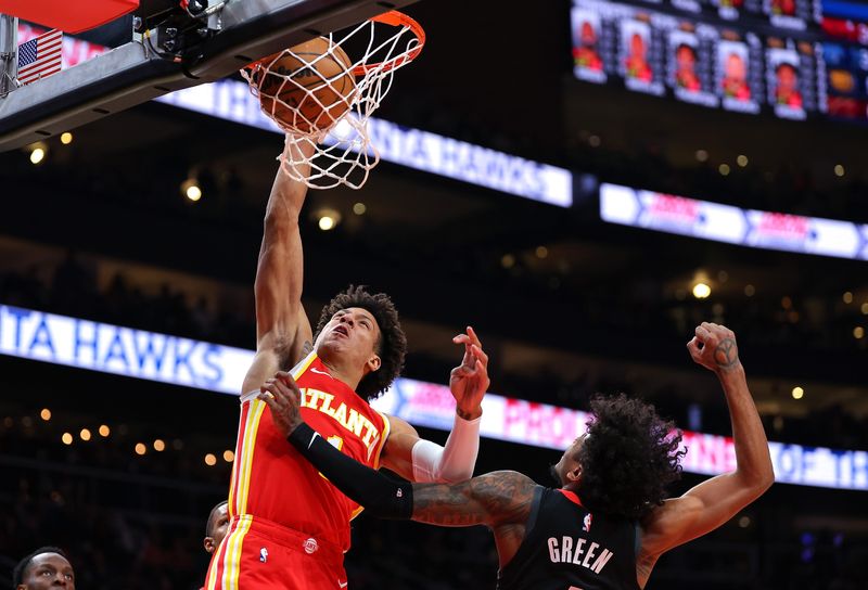 ATLANTA, GEORGIA - FEBRUARY 10:  Jalen Johnson #1 of the Atlanta Hawks dunks against Jalen Green #4 of the Houston Rockets during the first quarter at State Farm Arena on February 10, 2024 in Atlanta, Georgia.  NOTE TO USER: User expressly acknowledges and agrees that, by downloading and/or using this photograph, user is consenting to the terms and conditions of the Getty Images License Agreement.  (Photo by Kevin C. Cox/Getty Images)