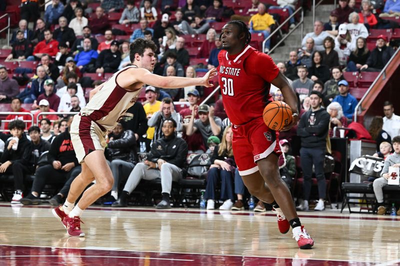 Feb 11, 2023; Chestnut Hill, Massachusetts, USA; North Carolina State Wolfpack forward D.J. Burns Jr. (30) dribbles the ball in front of Boston College Eagles forward Quinten Post (12)  during the second half at the Conte Forum. Mandatory Credit: Brian Fluharty-USA TODAY Sports