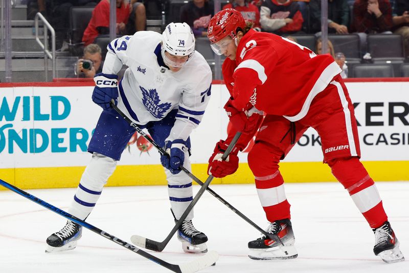 Oct 3, 2024; Detroit, Michigan, USA;  Toronto Maple Leafs center Bobby McMann (74) and Detroit Red Wings defenseman Moritz Seider (53) battle for the puck in the first period at Little Caesars Arena. Mandatory Credit: Rick Osentoski-Imagn Images