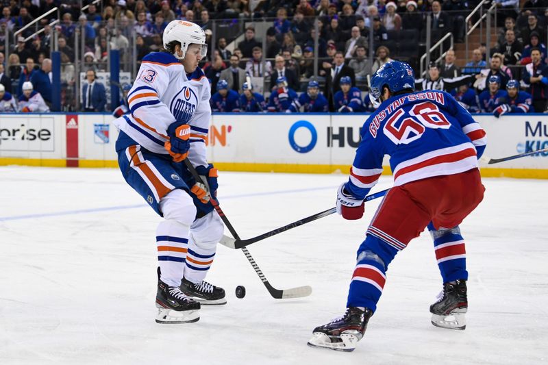 Dec 22, 2023; New York, New York, USA;  Edmonton Oilers center Mattias Janmark (13) and New York Rangers defenseman Erik Gustafsson (56) battle for a loose puck during the first period at Madison Square Garden. Mandatory Credit: Dennis Schneidler-USA TODAY Sports