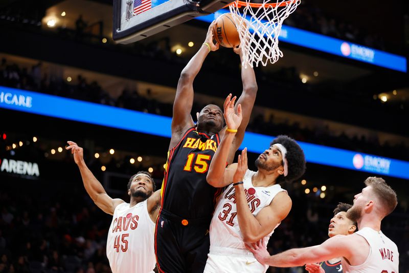 ATLANTA, GEORGIA - JANUARY 20: Clint Capela #15 of the Atlanta Hawks dunks the ball over Donovan Mitchell #45 of the Cleveland Cavaliers and Jarrett Allen #31 during the second half at State Farm Arena on January 20, 2024 in Atlanta, Georgia. NOTE TO USER: User expressly acknowledges and agrees that, by downloading and or using this photograph, User is consenting to the terms and conditions of the Getty Images License Agreement. (Photo by Alex Slitz/Getty Images)