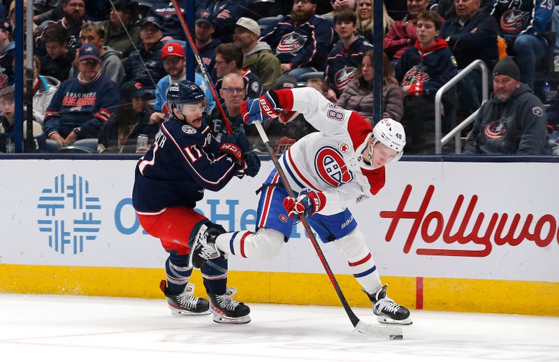 Nov 27, 2024; Columbus, Ohio, USA; Montreal Canadiens defenseman Lane Hutson (48) passes the puck as  Columbus Blue Jackets right wing Justin Danforth (17) trails the play during the first period at Nationwide Arena. Mandatory Credit: Russell LaBounty-Imagn Images