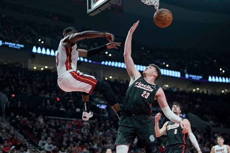 PORTLAND, OREGON - JANUARY 11: Bam Adebayo #13 of the Miami Heat passes the ball as Donovan Clingan #23 of the Portland Trail Blazers defends during the first half against the Portland Trail Blazers at Moda Center on January 11, 2025 in Portland, Oregon. NOTE TO USER: User expressly acknowledges and agrees that, by downloading and or using this photograph, User is consenting to the terms and conditions of the Getty Images License Agreement. (Photo by Soobum Im/Getty Images)